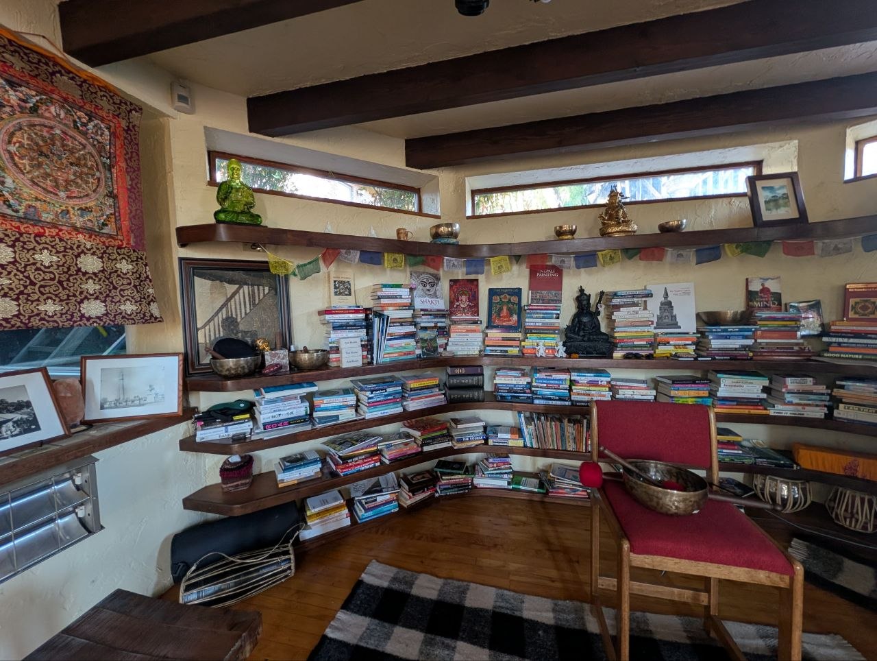 The Intimate Sanctuary Zone at OmOrenda.space with curved bookshelves, Tibetan singing bowls, and Himalayan textiles
