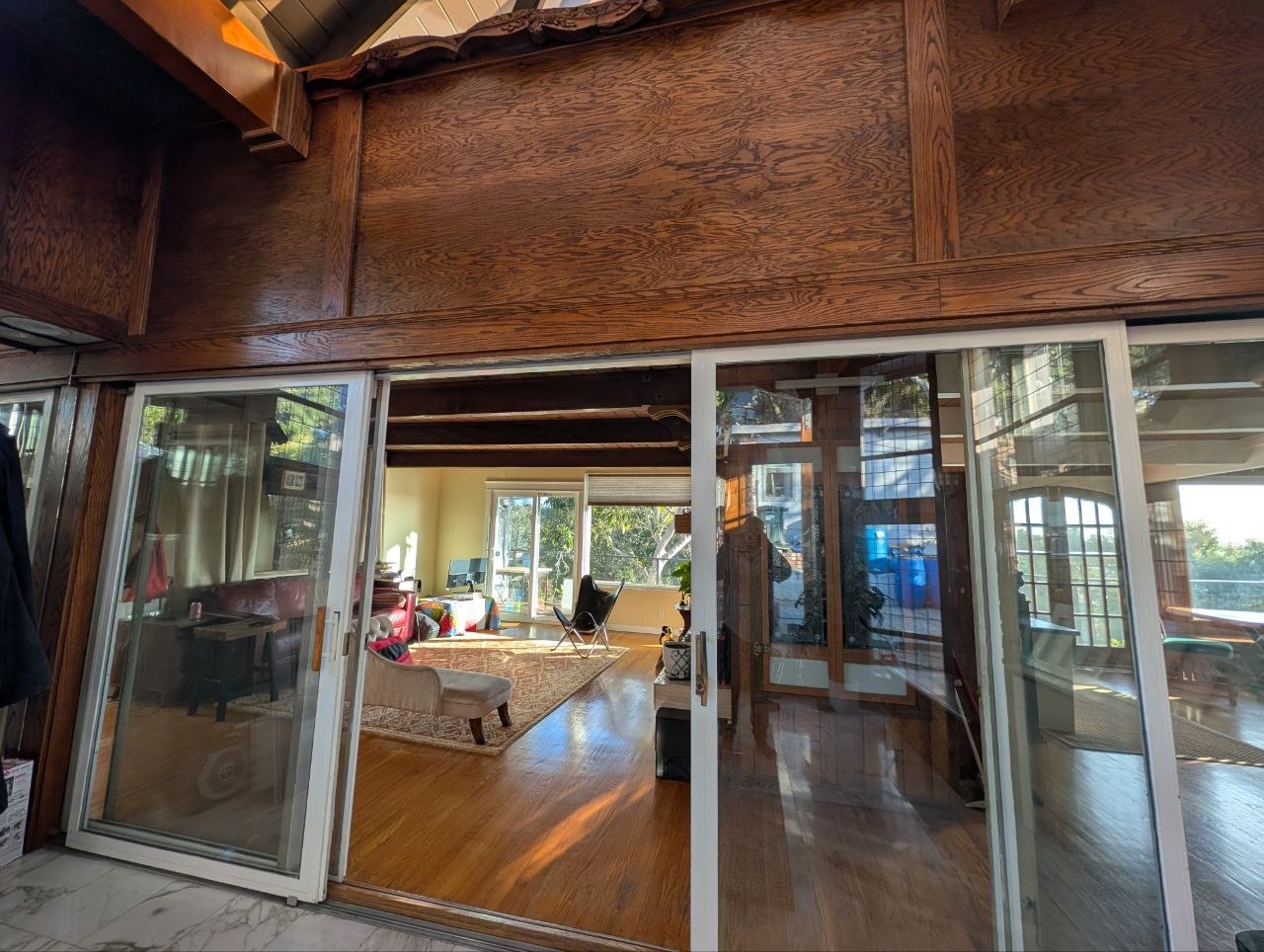 Sliding glass doors framing warm hardwood floors and open living room at OmOrenda.space