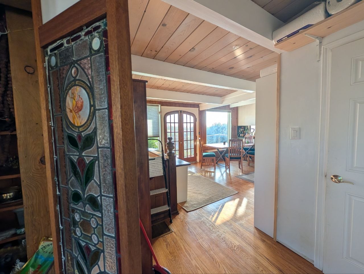 Sunlit dining hall framed by antique stained-glass portal at OmOrenda.space