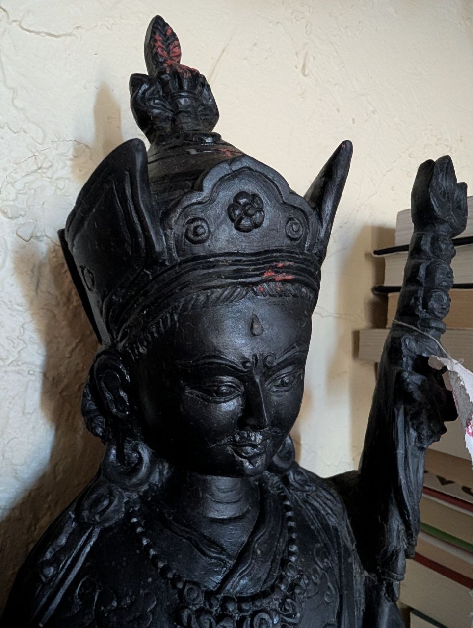 Close-up of Guru Padmasambhava showing the intricate Newar basalt stone carving and Lotus Crown